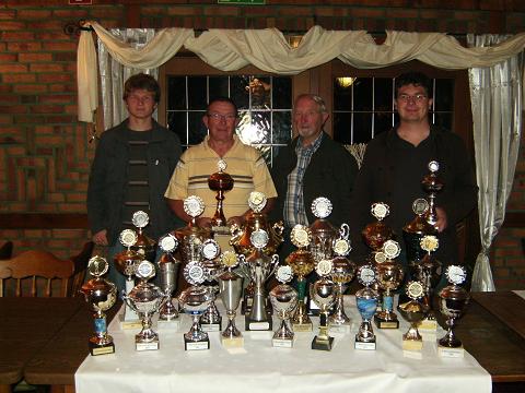 Die Ludgerus-Schützen aus Harwick mit dem Familientrio Vater Paul Finnah und Söhnen Thomas und Ulrich sowie Hartmut Lieneweg und ein paar der gewonnenen Pokalen seit Ihrem bestehen.